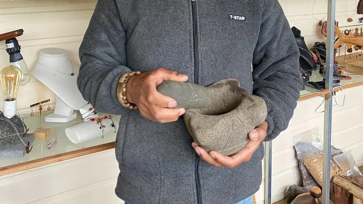 Josian tenant un pilon taillé dans la roche volcanique