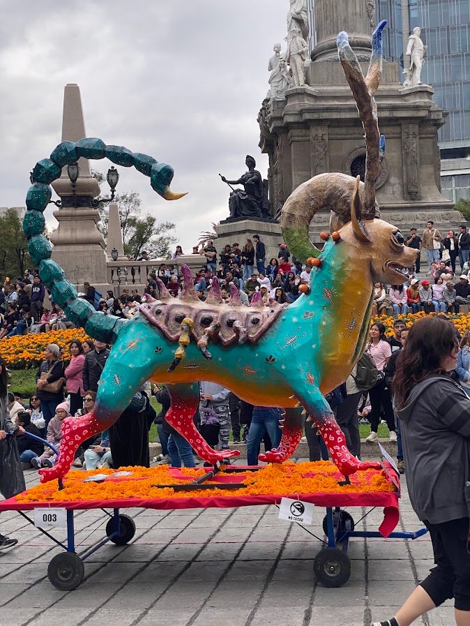 Alebrije turquoise à queue de scorpion et cornes de bélier sur un lit de cempasúchil
