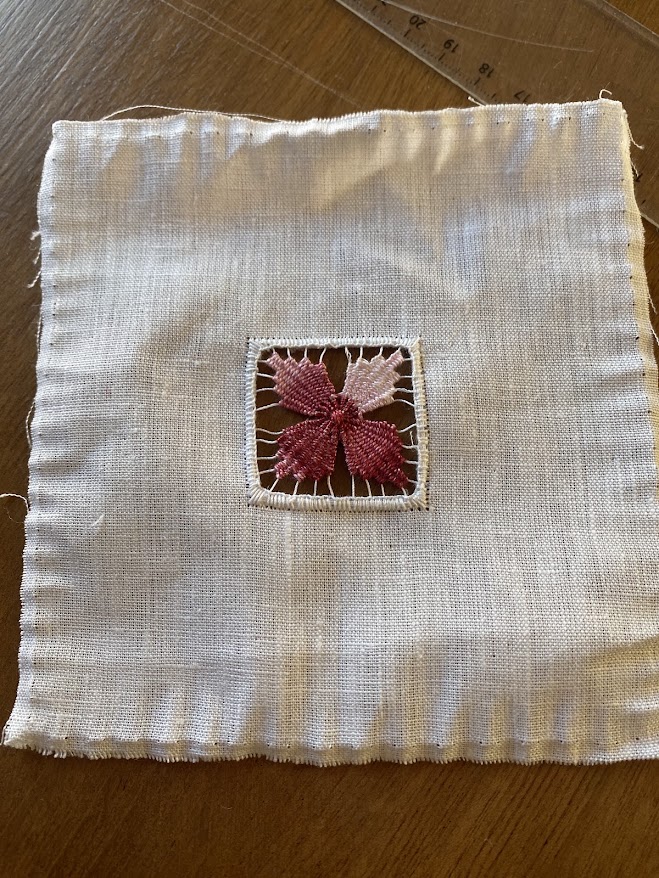Un motif de fleur brodé en jour de Cilaos sur du lin blanc